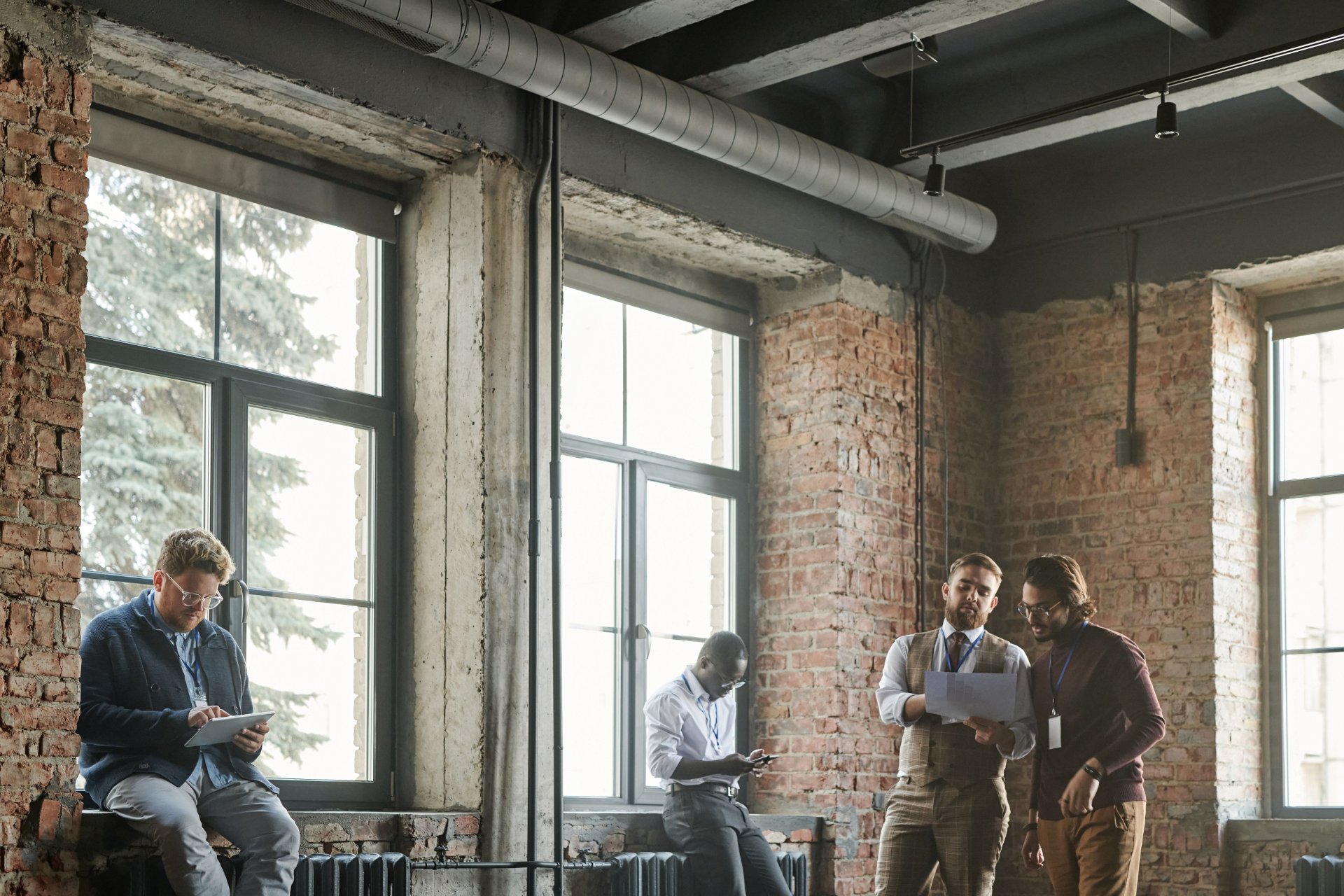 Colleagues reviewing project plans together in a brick and timber loft office