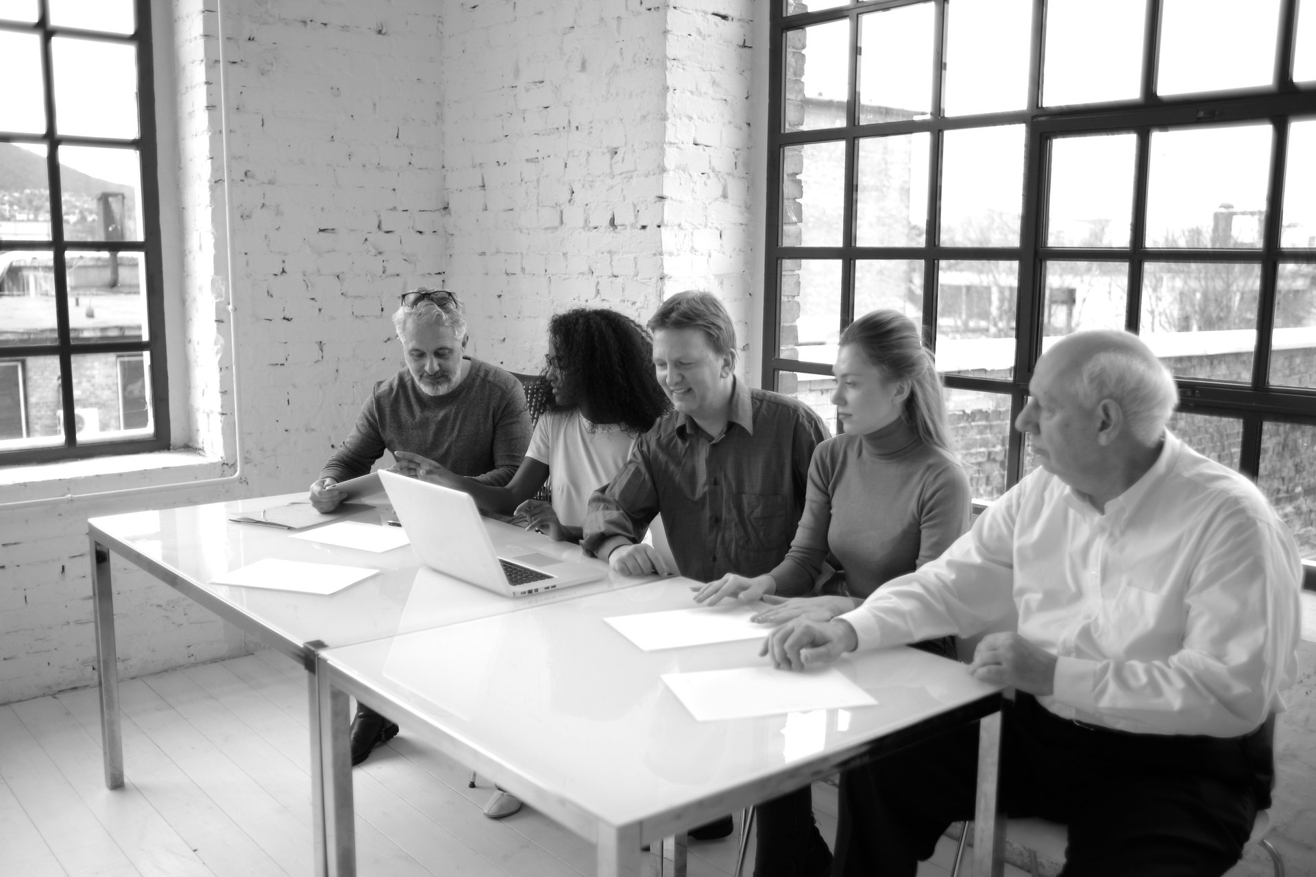 Colleagues reviewing strategic priorities together at a table near large industrial windows