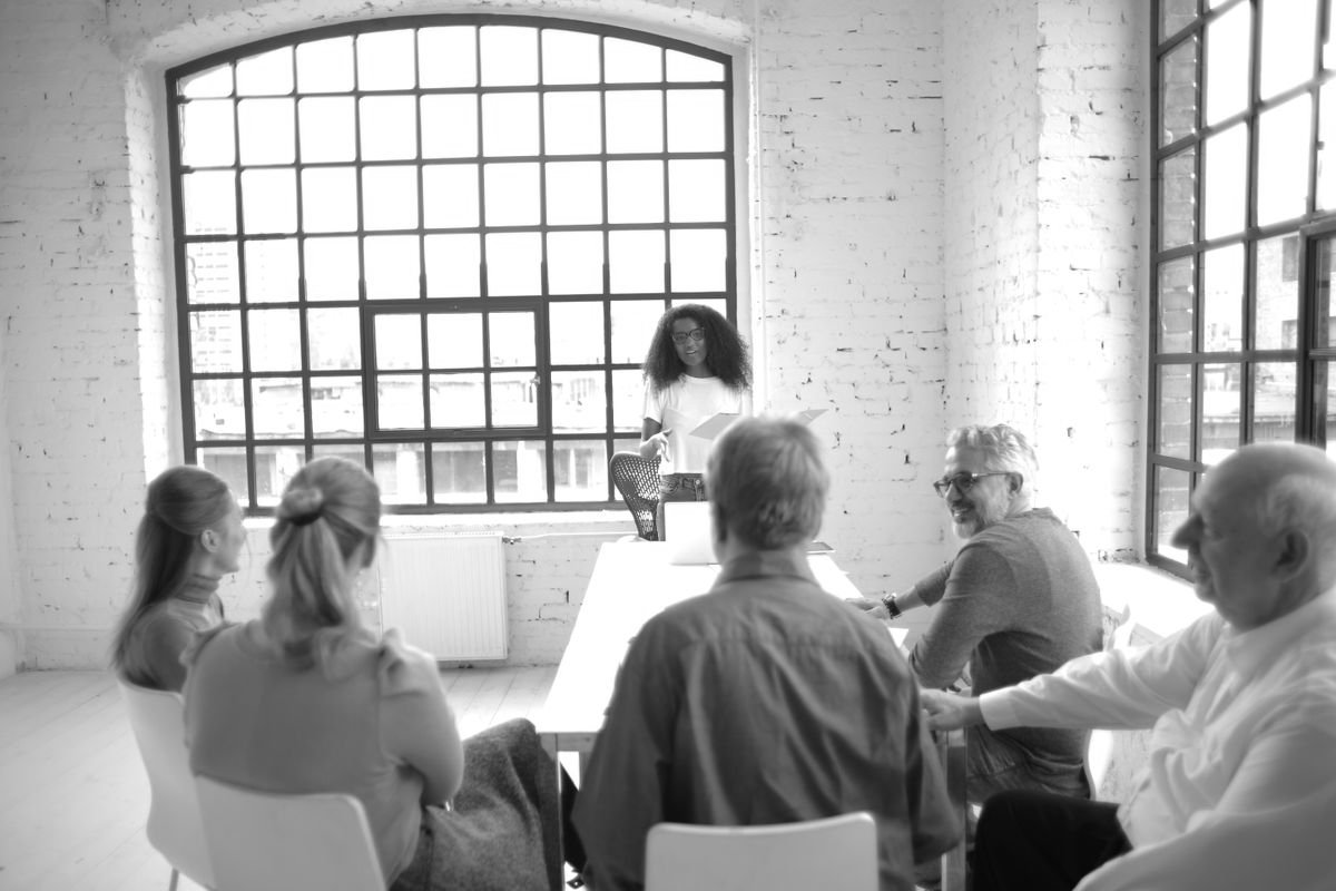 Leadership team reviewing portfolio priorities around a table in a bright loft office