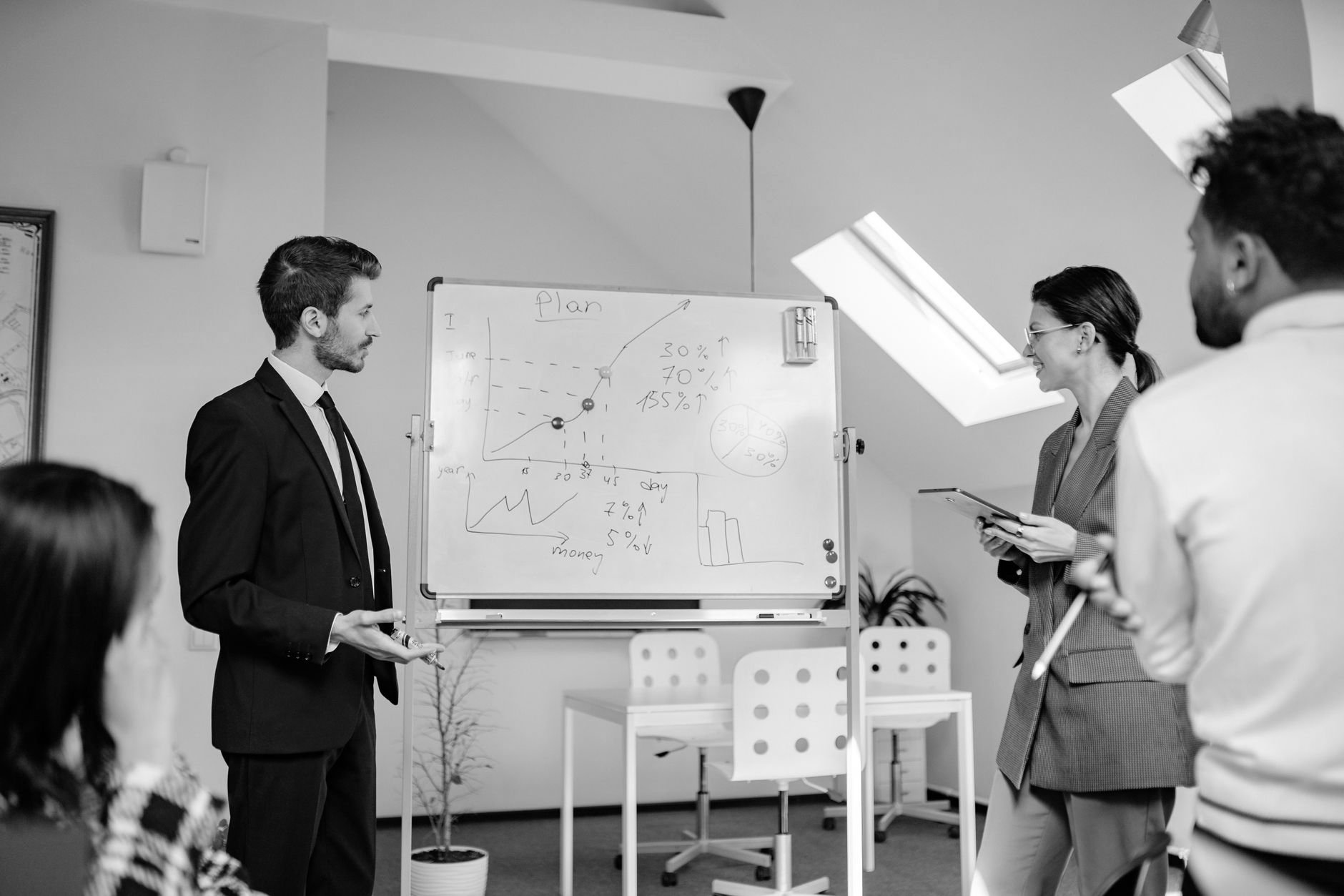 Program team reviewing a plan on a whiteboard in a bright office