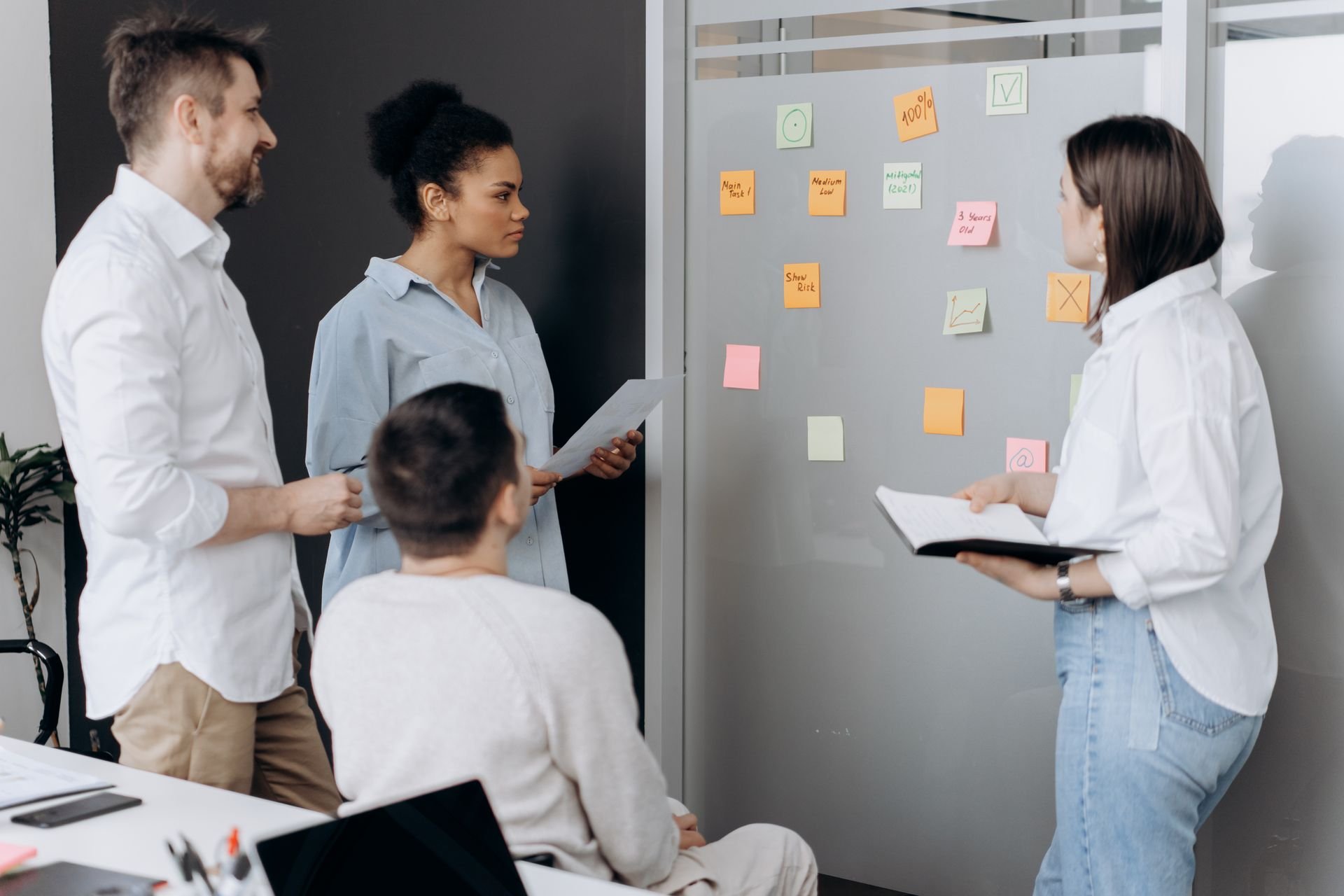 Team reviewing sticky notes on a wall while organizing work together